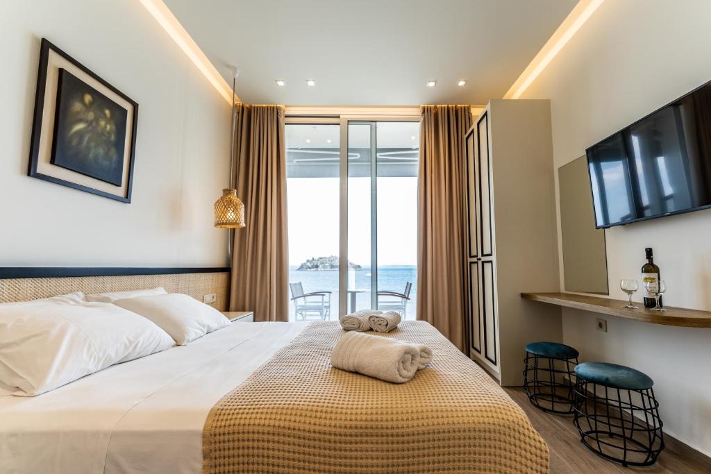 Una habitación de hotel con una cama con una toalla. en Mari Hotel & Maisonettes en Tolón