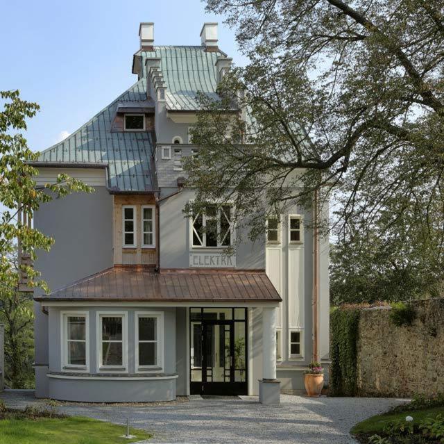 a large white house with a metal roof at Penzion Vila Elektra in Bechyně