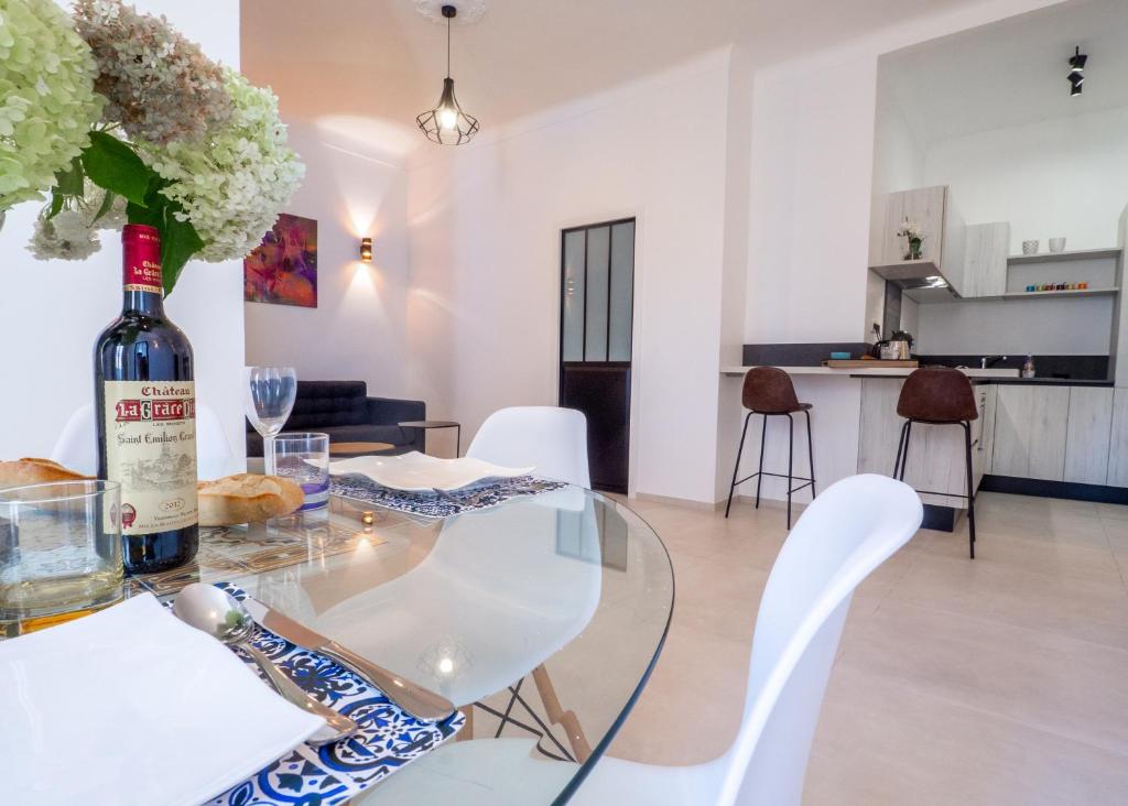- une bouteille de vin sur une table en verre dans le salon dans l'établissement Grand appartement 4 pièces centre de Cannes, à Cannes