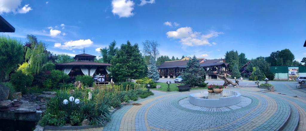 a building with a fountain in the middle of a park at Міні-готель "ЕКО" in Kamianets-Podilskyi