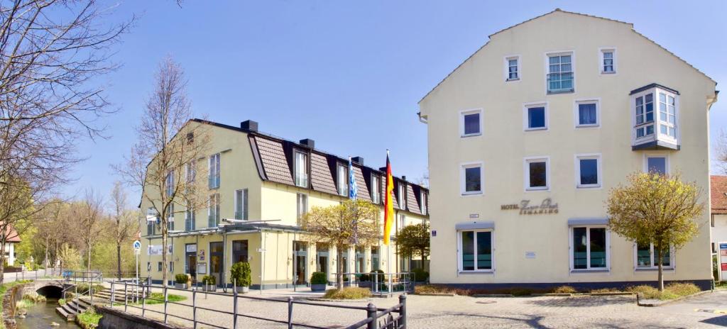 un edificio bianco con una recinzione di fronte di Hotel Zur Post a Ismaning