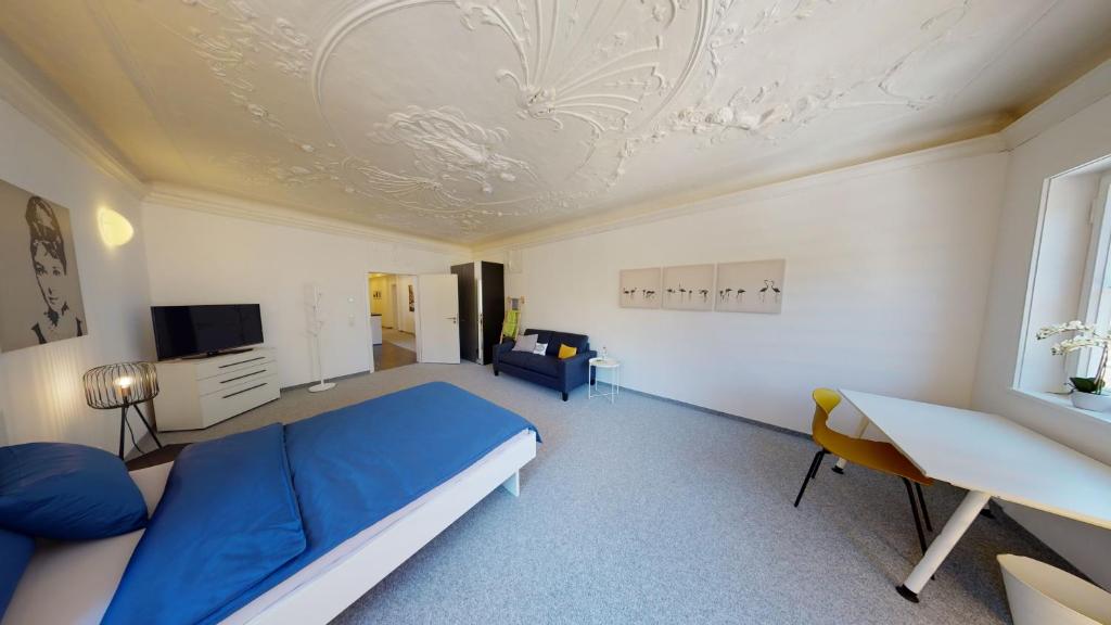 um quarto com uma cama azul e um sofá em Karl V - Geschichte leben im Herzen der Altstadt em Schwäbisch Hall