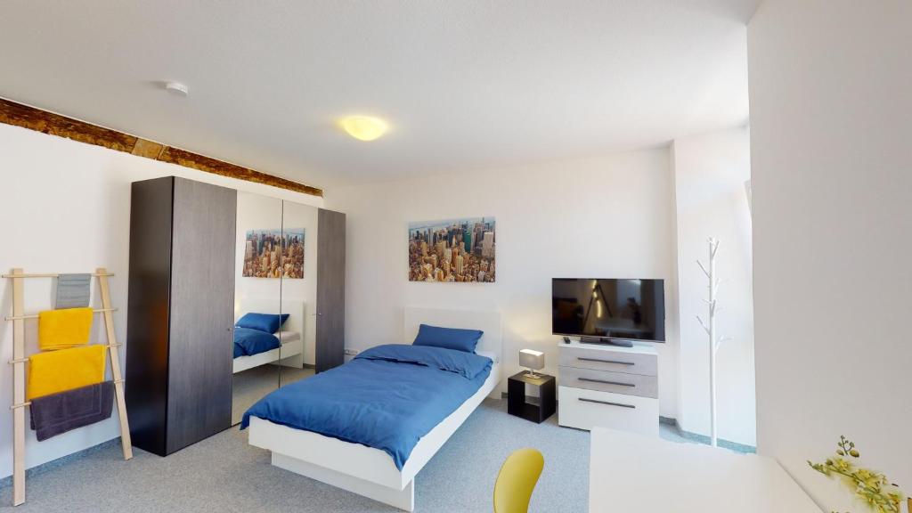 a bedroom with a blue bed and a television at Karl V - Geschichte leben im Herzen der Altstadt in Schwäbisch Hall