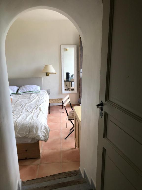 a bedroom with a bed and a desk and a chair at Mas de la Gonnette in Venasque