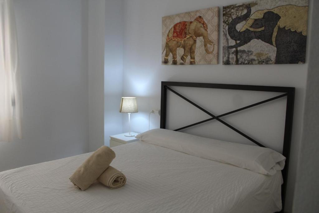 Un dormitorio con una cama con una toalla. en PISO EN PLENO CORAZÓN DE CORDOBA, en Córdoba