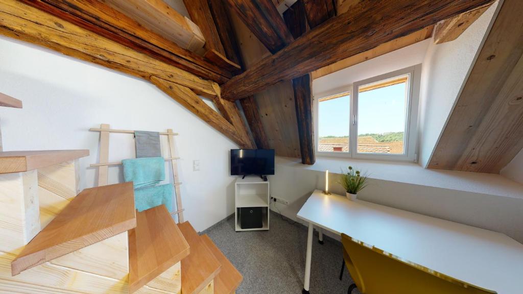 a room with wooden ceilings and a desk and a tv at Karl V - Geschichte leben im Herzen der Altstadt in Schwäbisch Hall
