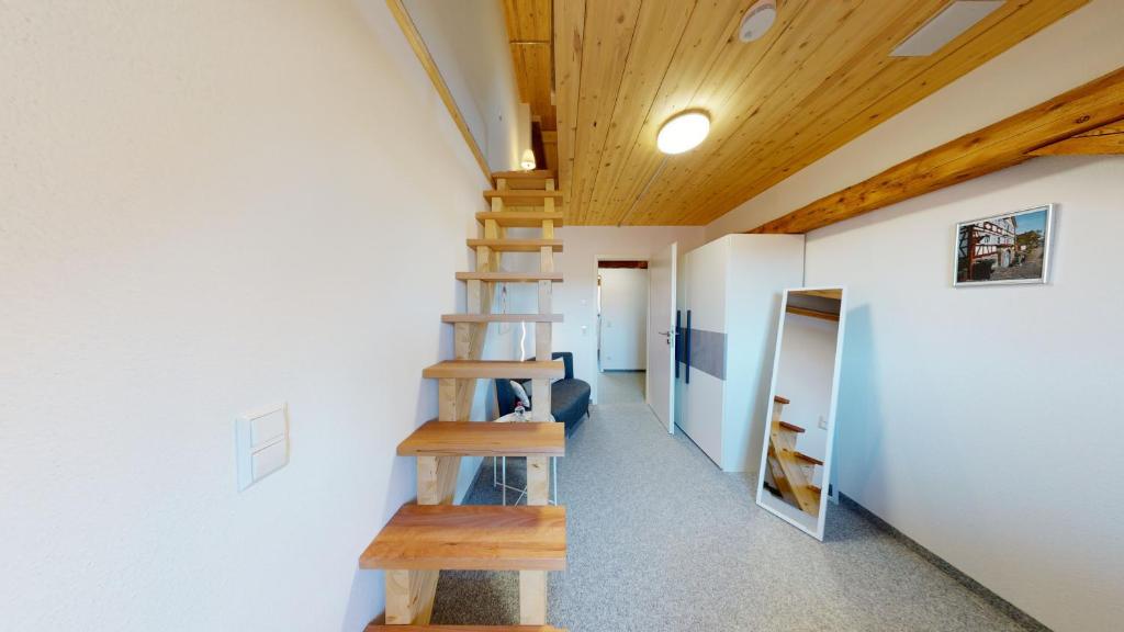 a wooden staircase in a room with a ceiling at Karl V - Geschichte leben im Herzen der Altstadt in Schwäbisch Hall