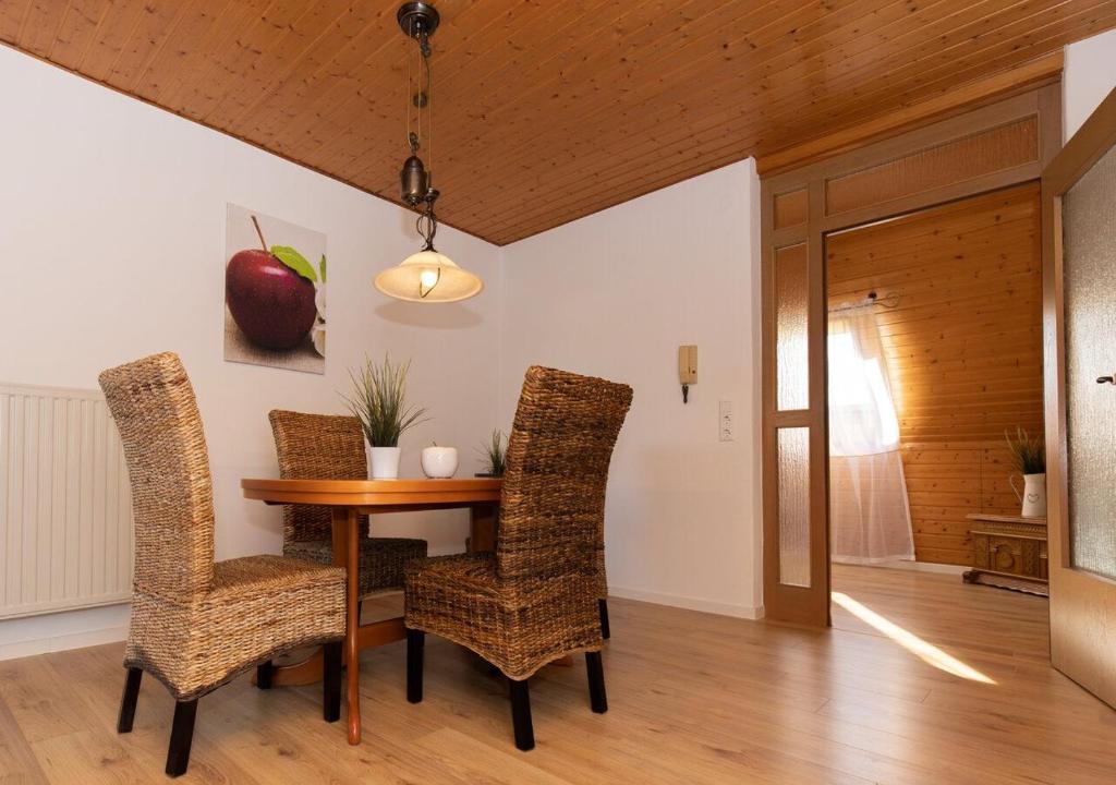 ein Esszimmer mit einem Tisch und Stühlen sowie einem Apfel an der Wand in der Unterkunft Ferienwohnung Apfelblüte in Burgbernheim