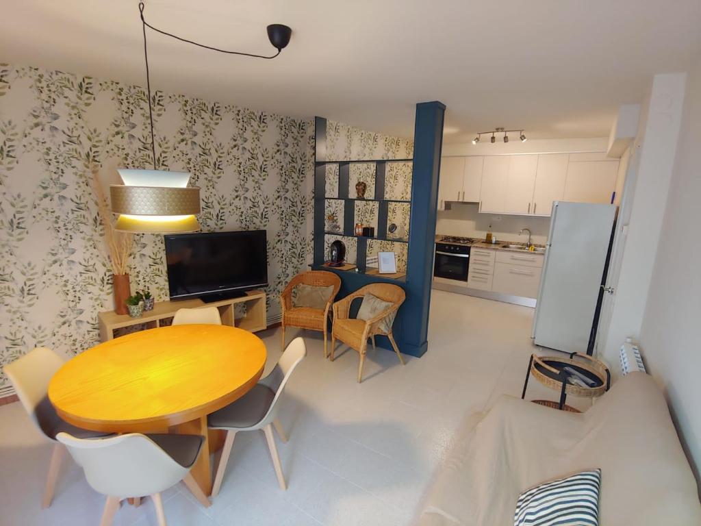 sala de estar con mesa y sillas y cocina en Lo Peressall Blau, en Tremp