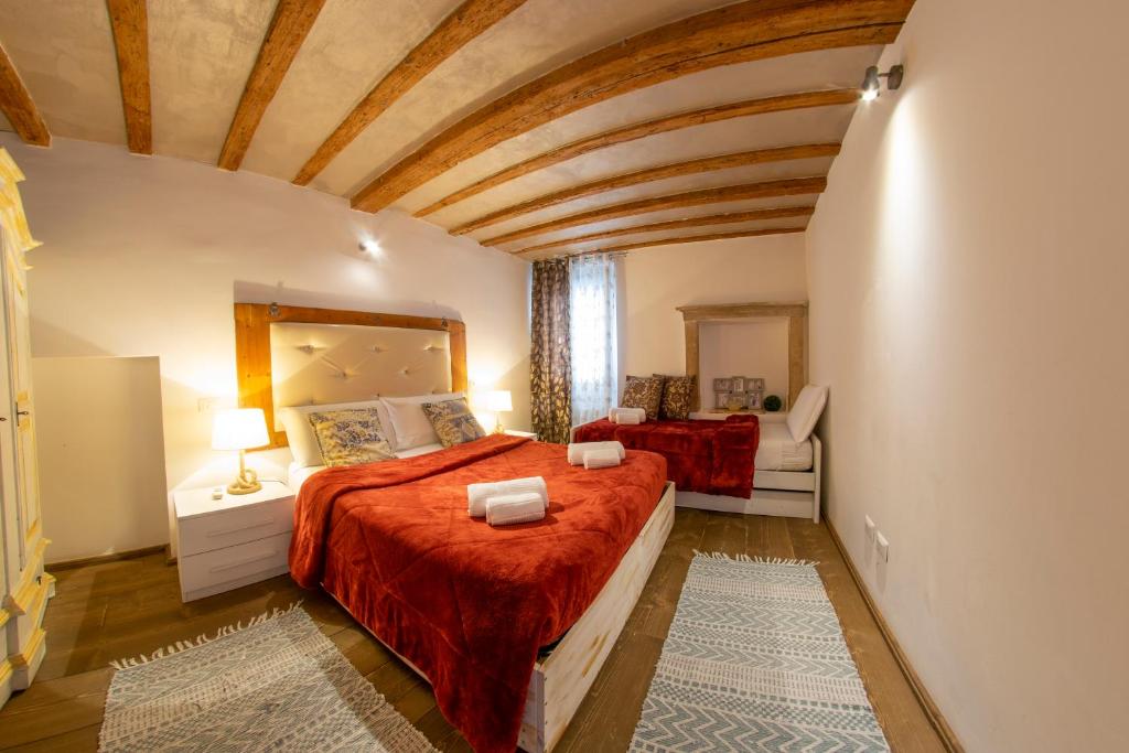 1 dormitorio con 1 cama grande con colcha roja en Marconi Rooms Alloggio Segreto, en Verona