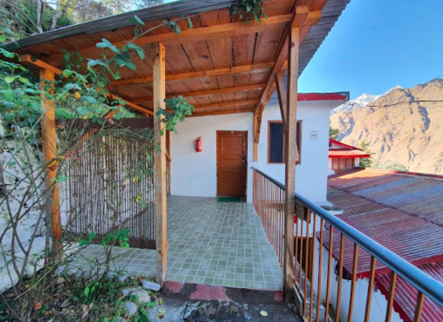 a porch of a house with a wooden roof at Resort With Mesmerizing Mountain Views & Pine Trees in Joshīmath