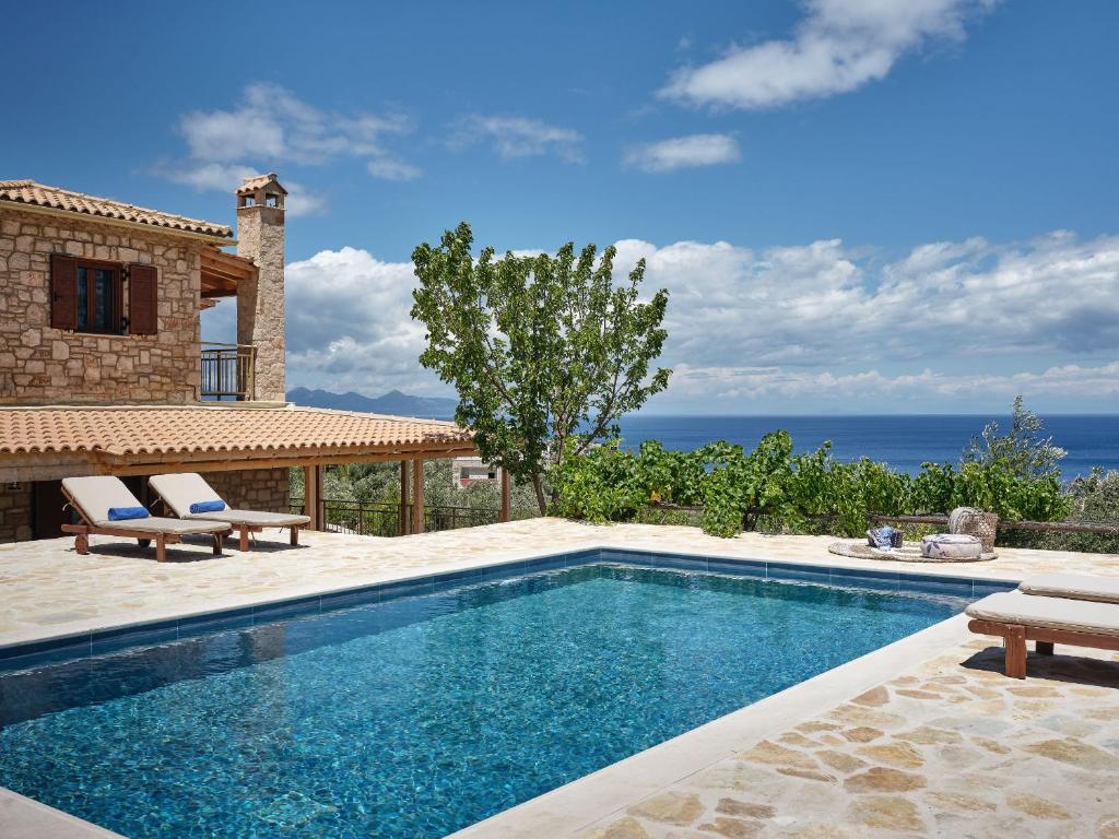 a swimming pool in front of a house at Arbarosa Villa in Agios Nikolaos