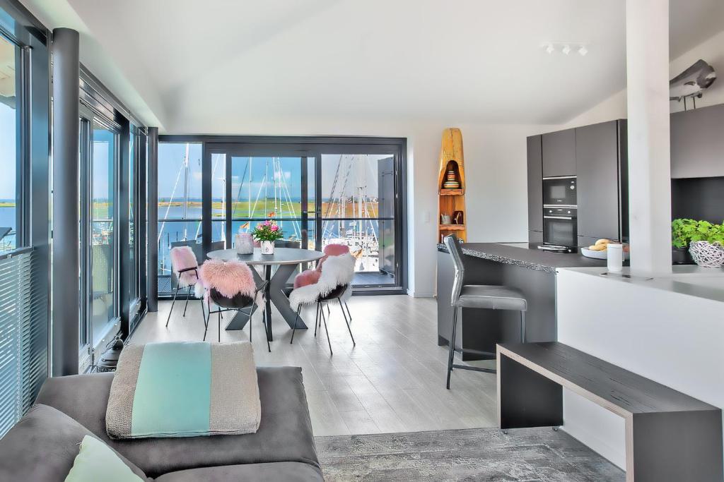 a kitchen and living room with a table and chairs at Hafenspitze No1 in Heiligenhafen