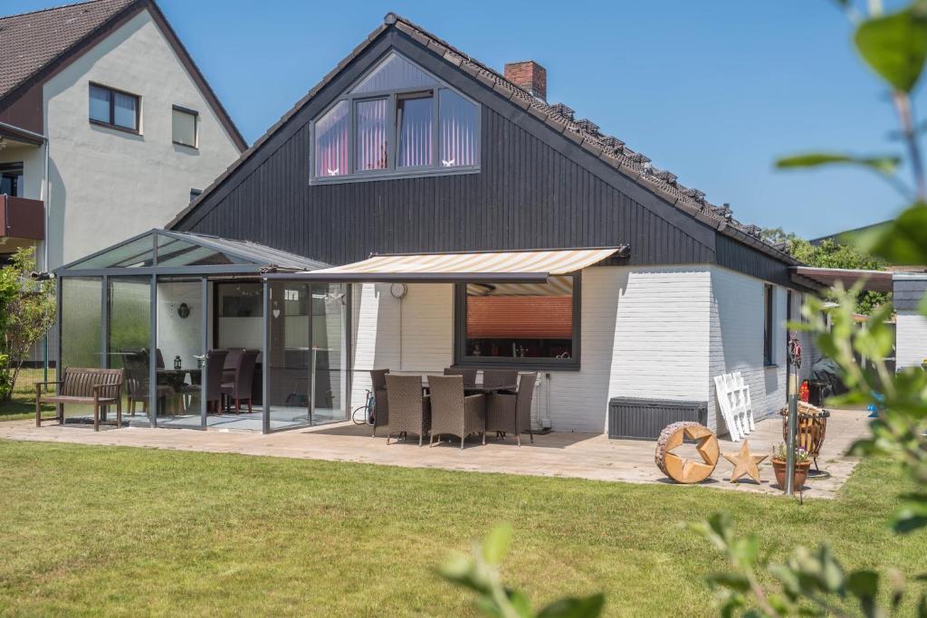 ein Haus mit einem schwarzen Dach und einer Terrasse in der Unterkunft Haus Jäschke in Bremerhaven