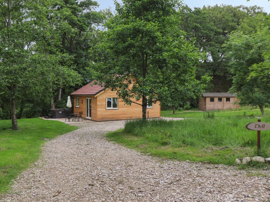 eine Hütte im Wald mit Schotterstraße in der Unterkunft Park Brook Dell in Preston