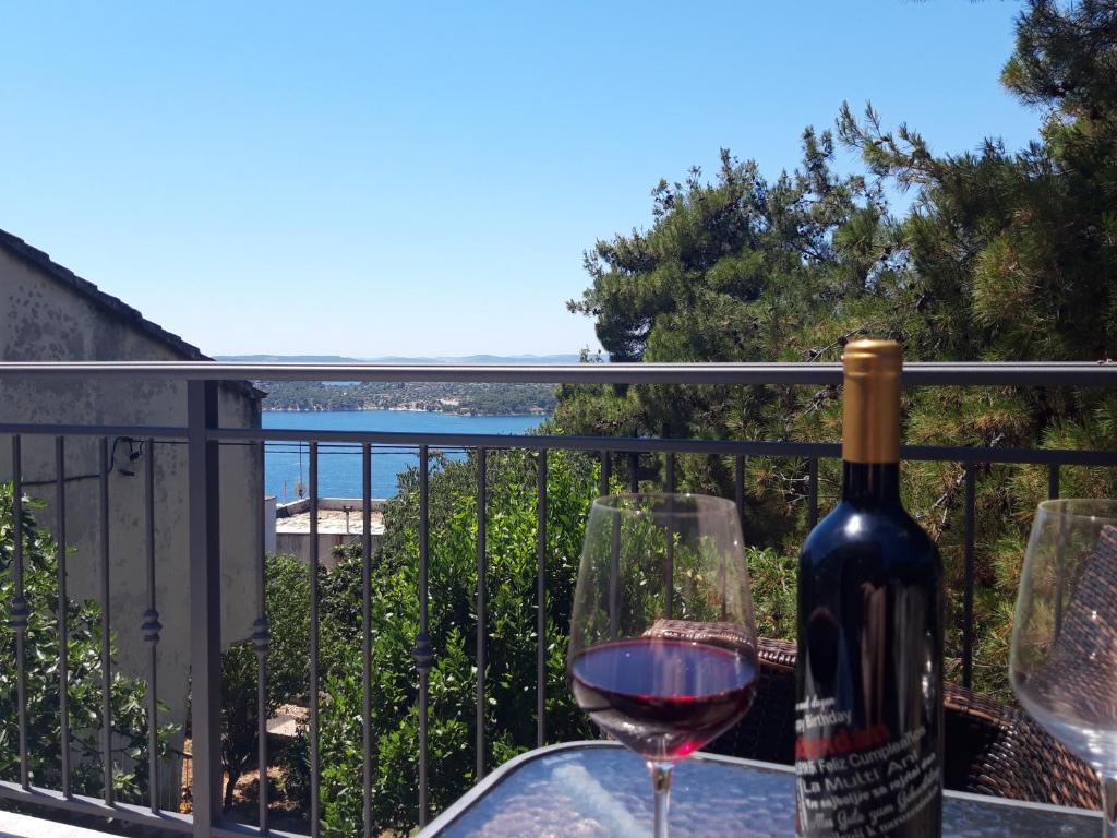 a bottle of wine and two glasses on a balcony at Apartmani Ponistra in Šibenik