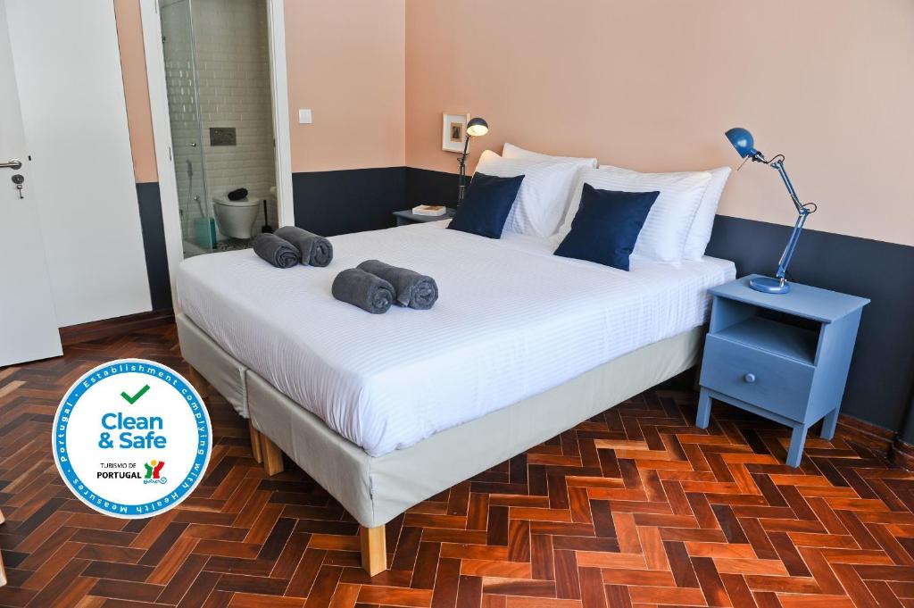 sypialnia z dużym łóżkiem z dwoma ręcznikami w obiekcie Lisbon Martinis Apartment 6A w Lizbonie