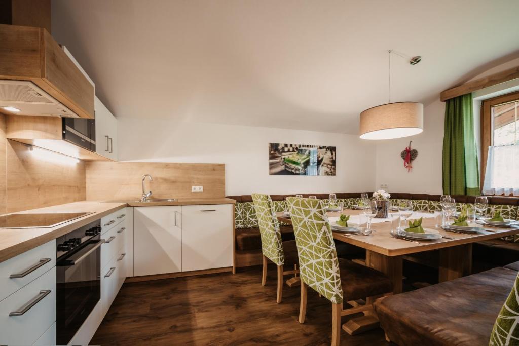 a kitchen with a dining room table and chairs at DAS "Bergzeit" - Appartements in Wagrain