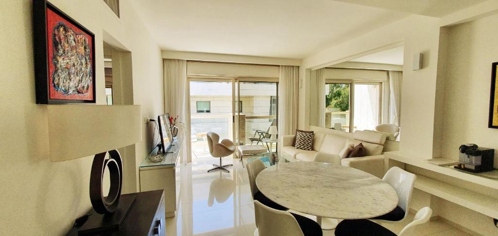 een woonkamer met een tafel en een bank bij BnBIsrael apartments - Ramat Yam Marine in Herzelia 
