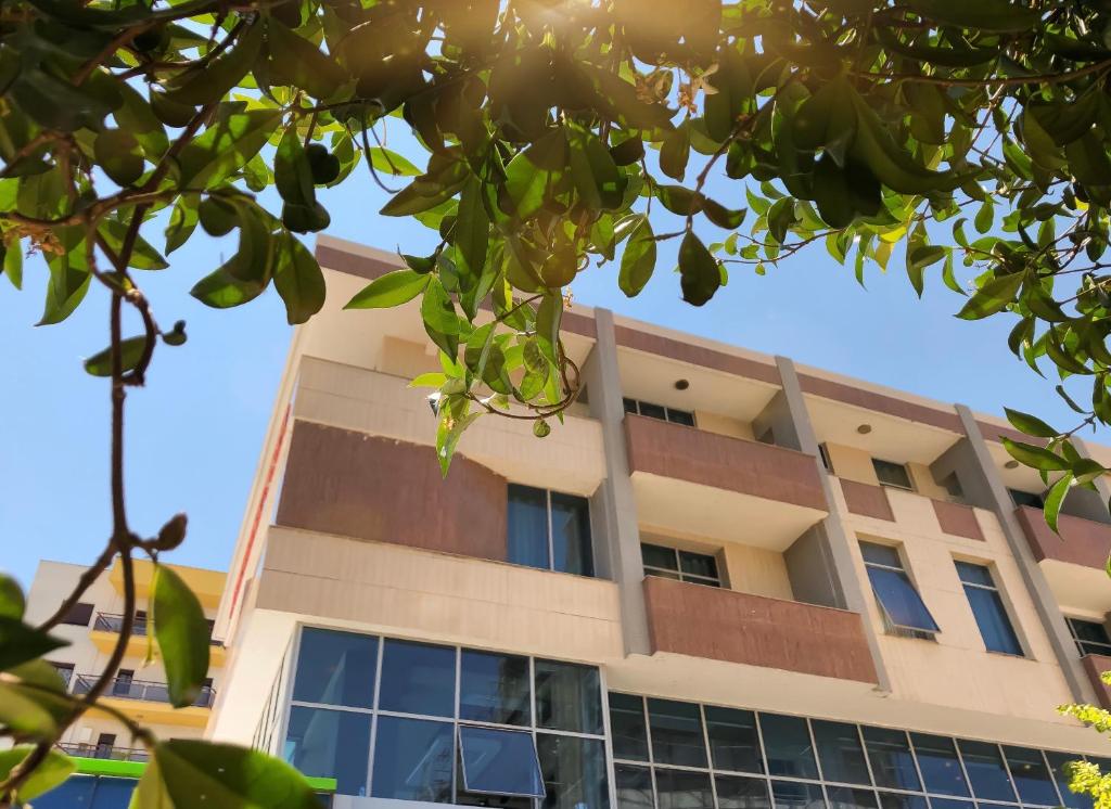 un edificio de apartamentos con el sol en el cielo en Hotel Kompleksi Arifi, en Shkodër