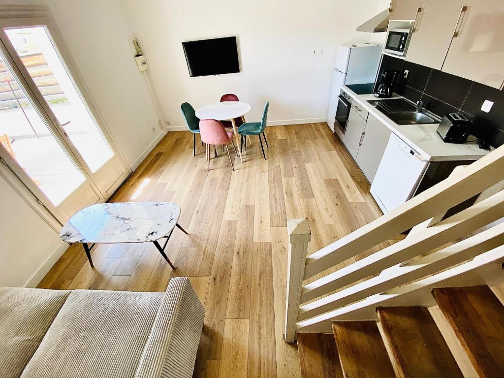 uma cozinha e uma sala de estar com mesa e cadeiras em Propriété Malva appartement bergamotta em Alata