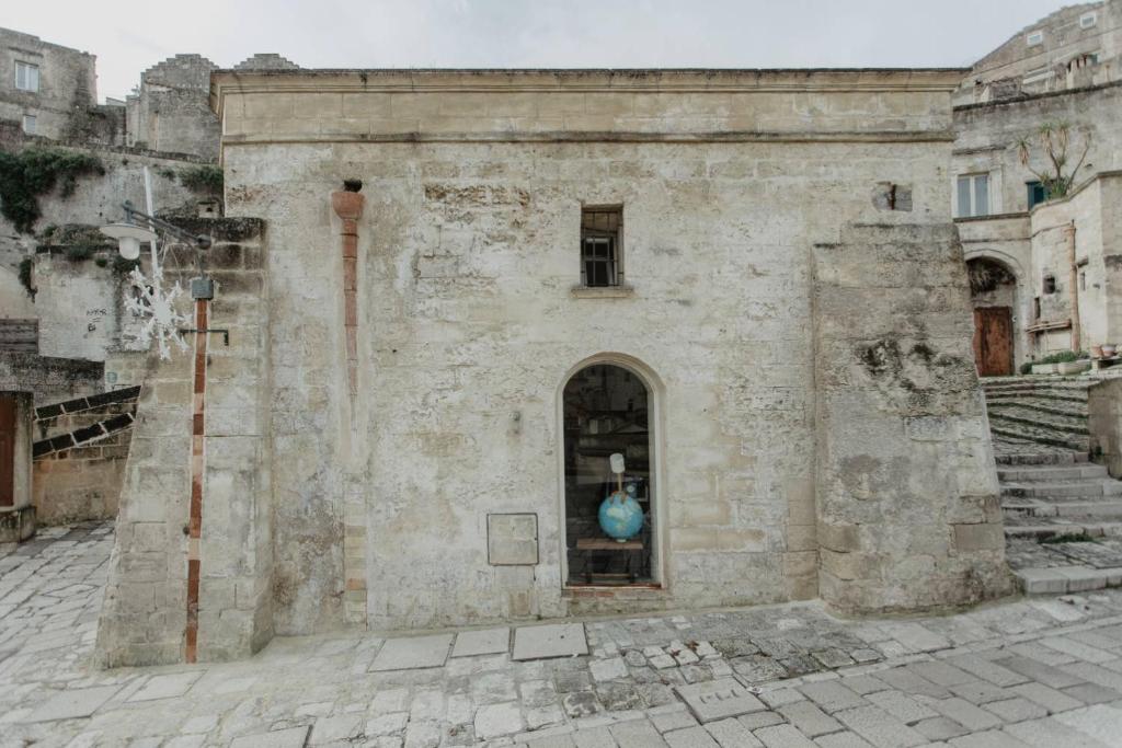 een oud gebouw met een blauwe vaas in een raam bij Pietragialla in Matera