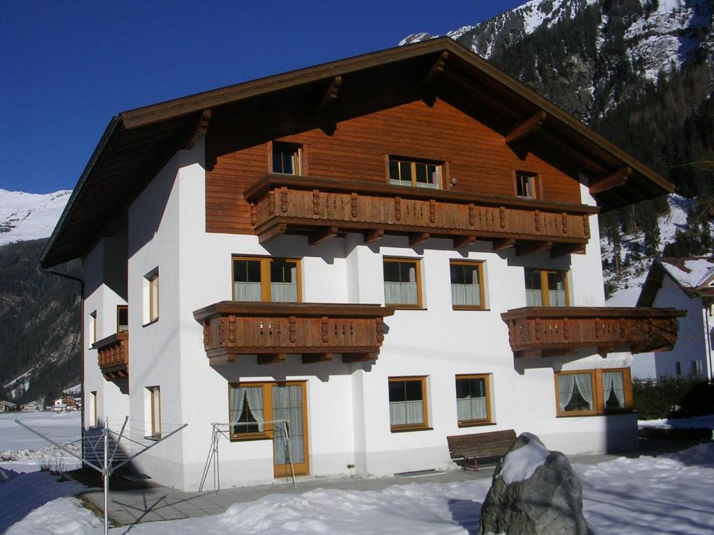 a large building with wooden balconies in the snow at Haus Hafele in Kaunertal