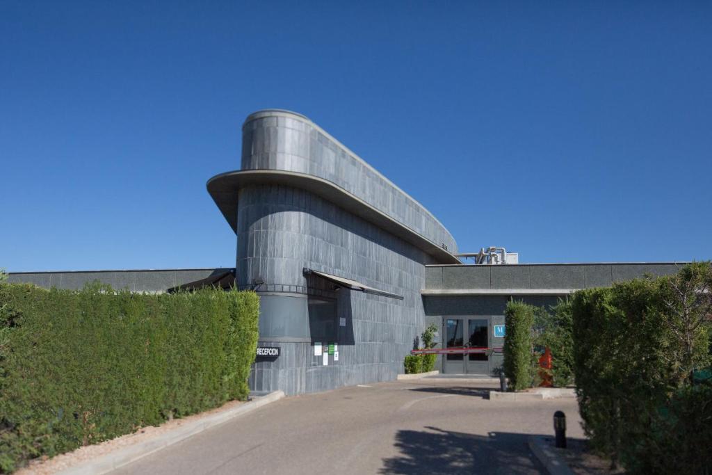 un grand bâtiment en béton avec une route devant lui dans l'établissement Motel Emporio, à Cabezón de Pisuerga