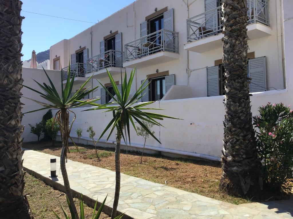 GrikosにあるJoanna Apart - Hotelのヤシの木が目の前に広がる白い建物