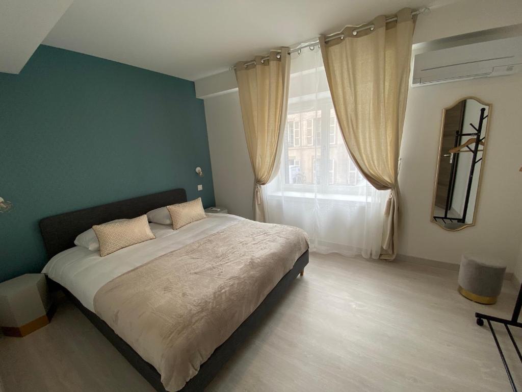 a bedroom with a large bed and a window at La Terrasse du Faubourg in Beaune