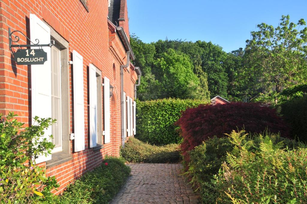 a brick building with a pathway next to a house at Boslucht Leuven in Heverlee