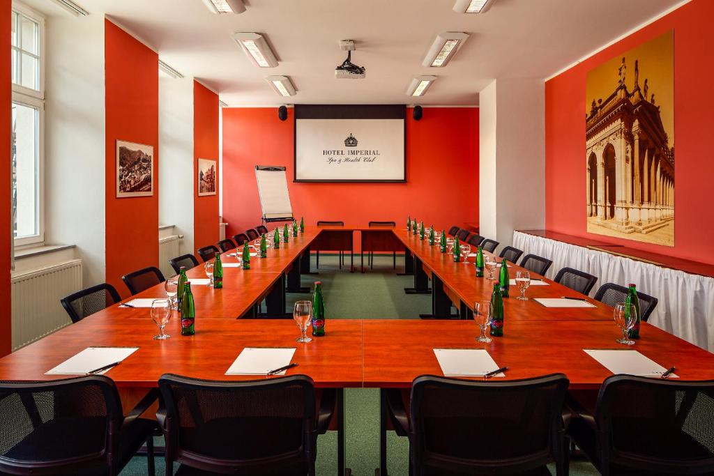 a long table in a room with red walls at Spa Hotel Imperial in Karlovy Vary