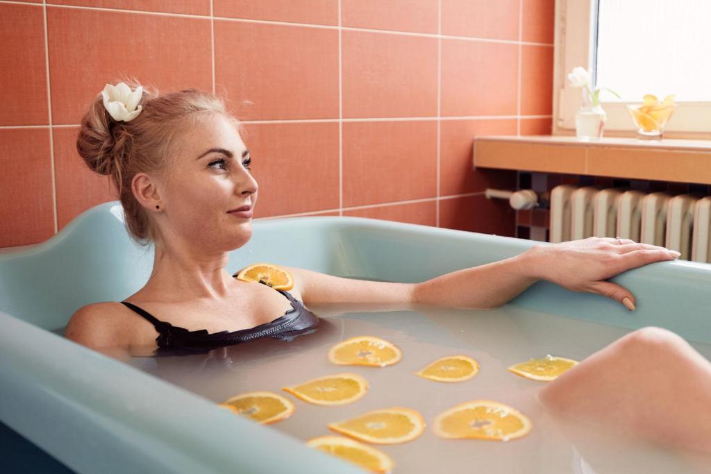 a woman sitting in a bath tub with orange slices at Spa Hotel Imperial in Karlovy Vary