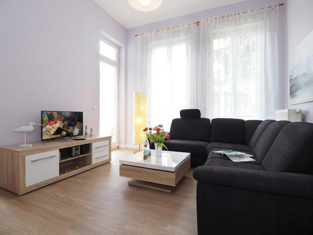 a living room with a couch and a tv at Villa Lucie Else 06 in Heringsdorf