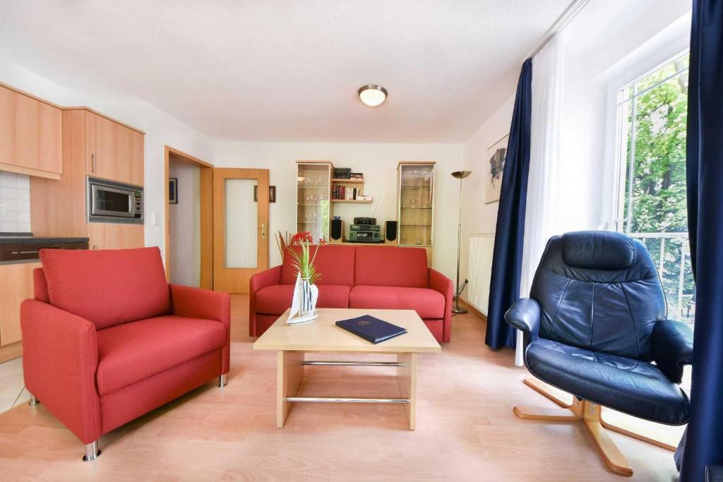 un soggiorno con 2 sedie rosse e un tavolo di Haus Strandoase 23 a Bansin