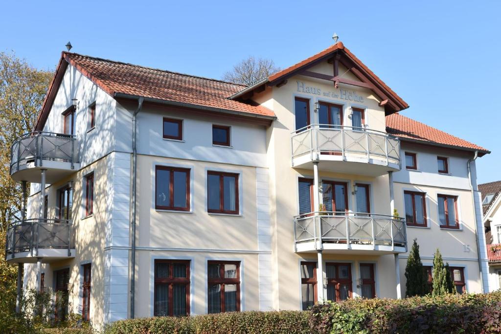 a white building with a red roof at Haus auf der Höhe - Panorama in Heringsdorf