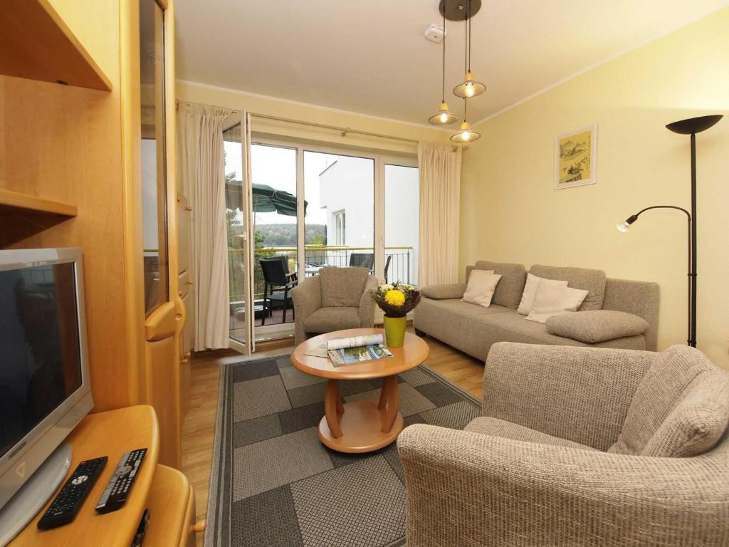 un soggiorno con divano e TV di Wohnung am Schloonsee B4 a Heringsdorf