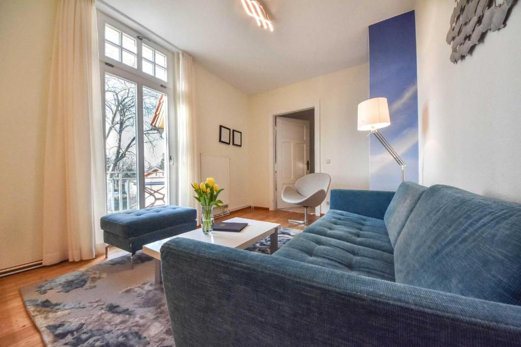 ヘリングスドルフにあるVilla Emmy Wohnung 7のリビングルーム(青いソファ、テーブル付)