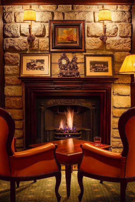 a living room with a fireplace and a table and chairs at Spa Hotel Imperial in Karlovy Vary