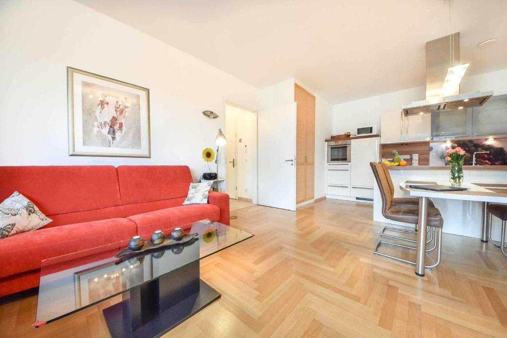 ein Wohnzimmer mit einem roten Sofa und einer Küche in der Unterkunft (49a) Penthouse Maxi in Heringsdorf