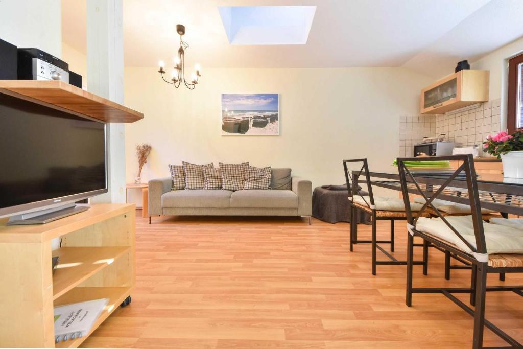 Una sala de estar con un sofá y un televisor. en Haus Lamora 08, en Heringsdorf