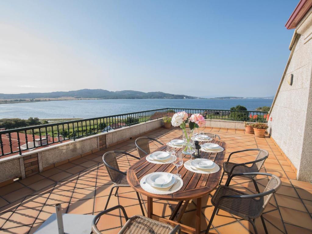 a table and chairs on a balcony with a view of the water at Atico con vistas a la Lanzada in A Lanzada