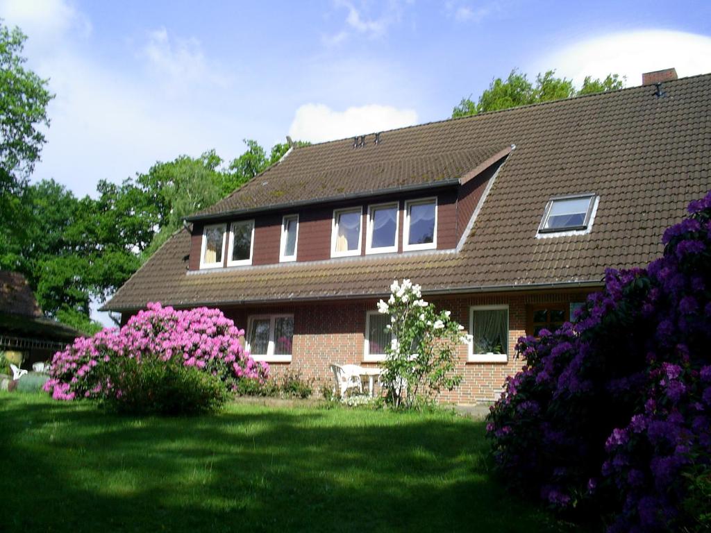 una casa con flores rosas en el patio en Rhododendronhof, en Behringen