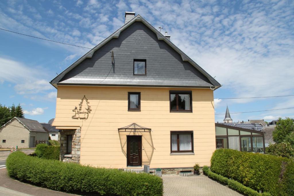 une maison jaune avec un toit gris dans l'établissement Casa Léon, à Bullange