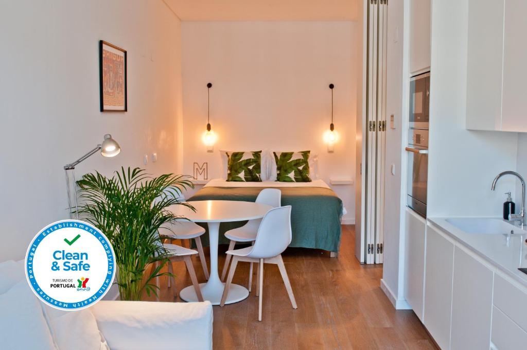 リスボンにあるUrban Jungleのベッド、テーブル、椅子が備わる小さなアパートメントです。