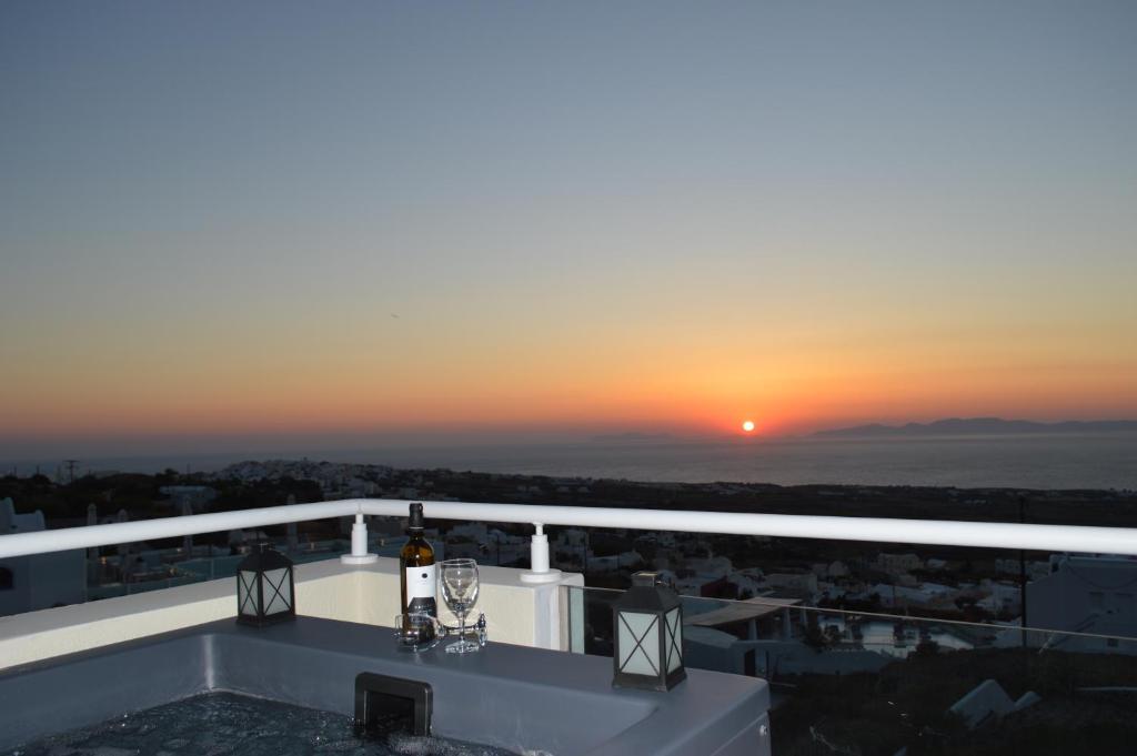 a view of the sunset from the balcony of a building at Kiklamino Sunset Studios in Oia