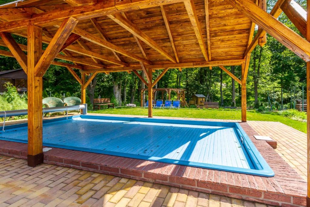 duży basen pod drewnianym pawilonem w obiekcie Penzion Kokorin Forest Villa w mieście Konrádov