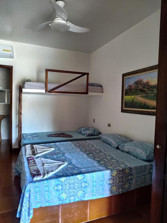 Schlafzimmer mit einem Bett mit blauer Decke in der Unterkunft Pousada Na Praia Ubatuba in Ubatuba