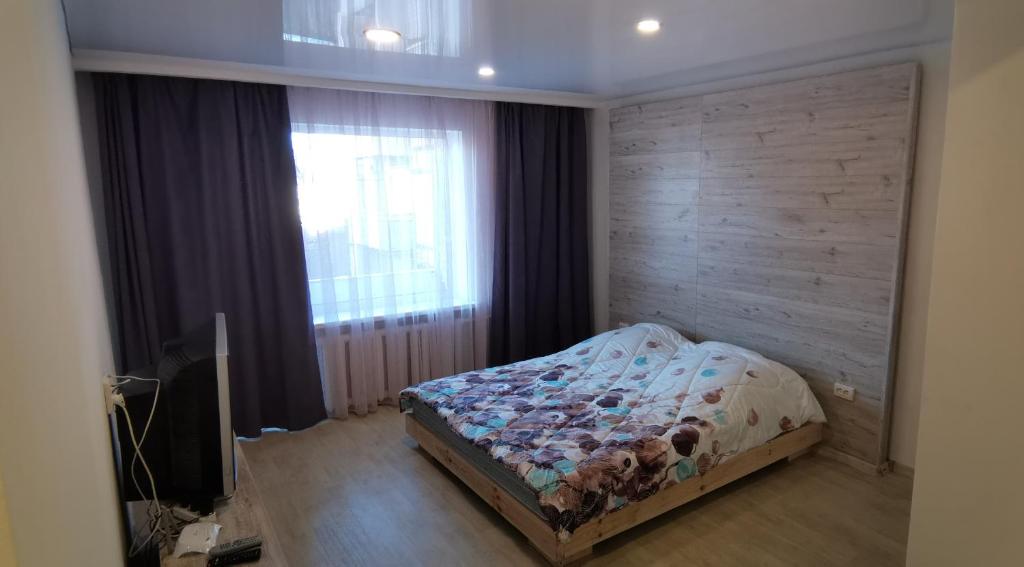 a bedroom with a bed in front of a window at Spas`ka Apartment in Peresadovka