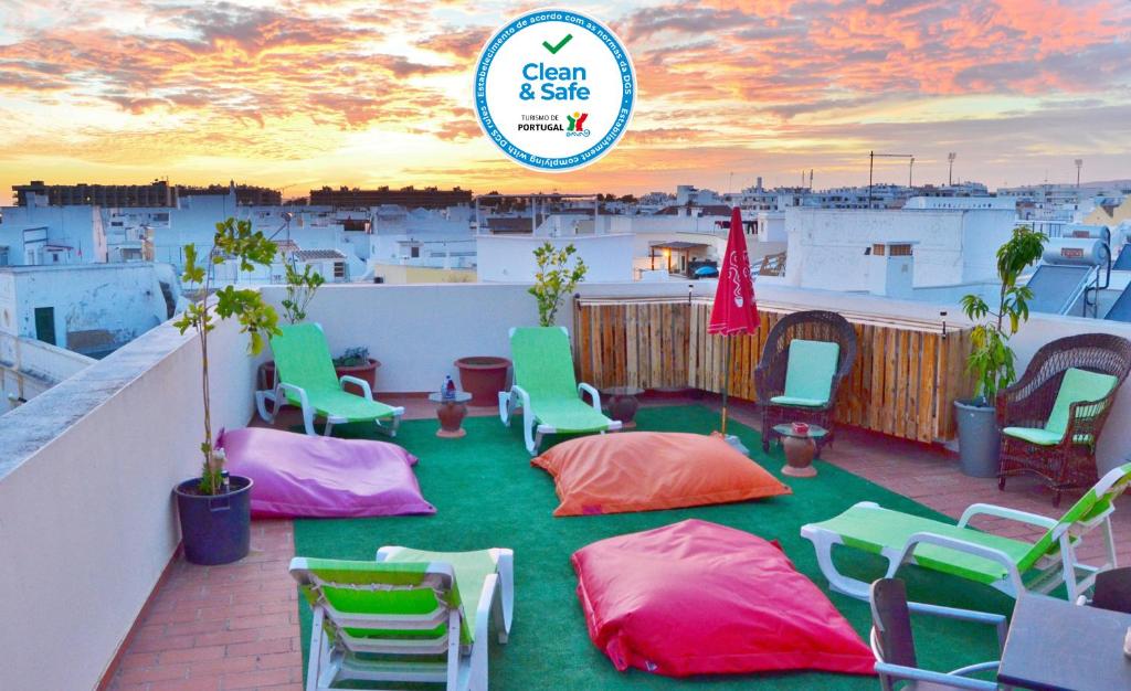 a balcony with colorful chairs and tables on a roof at BJB - Alojamentos in Olhão